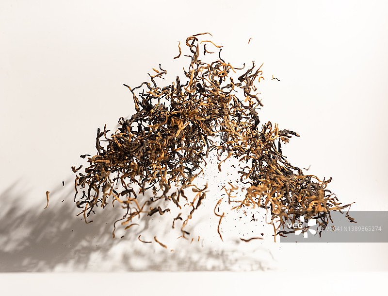 白色背景上飞舞的红茶叶图片素材