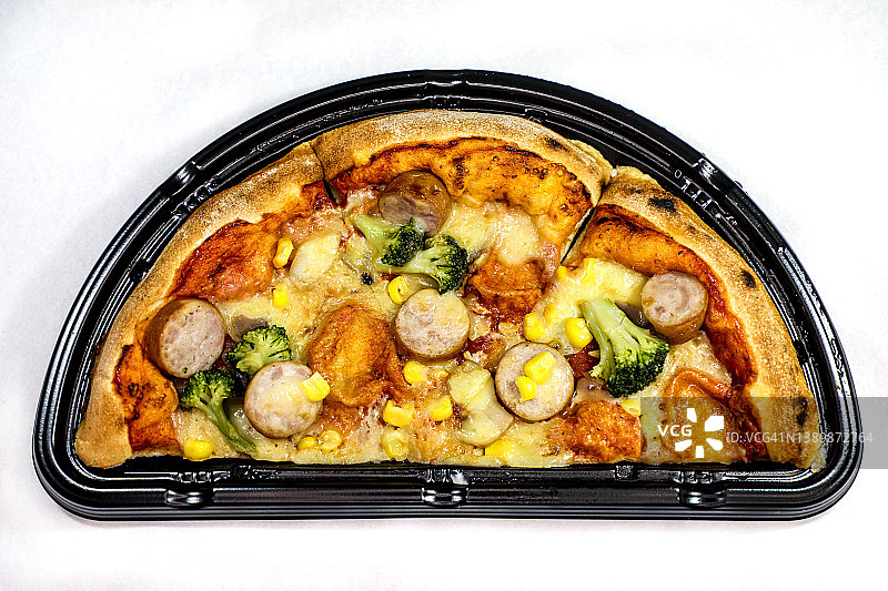 黑色外卖盒中对半切开的披萨图片素材