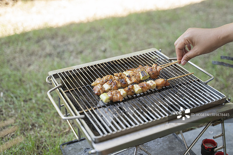 男人们在烤架上拿着烧烤钳图片素材