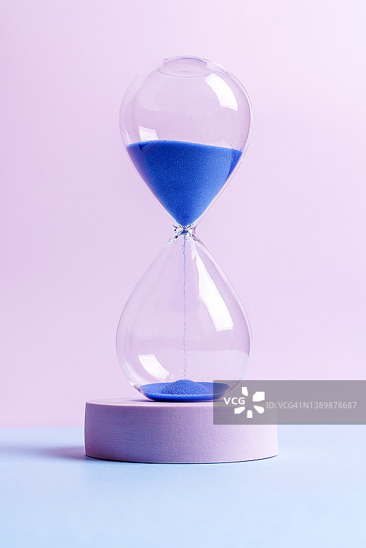 蓝色和粉色背景上的蓝色沙漏图片素材