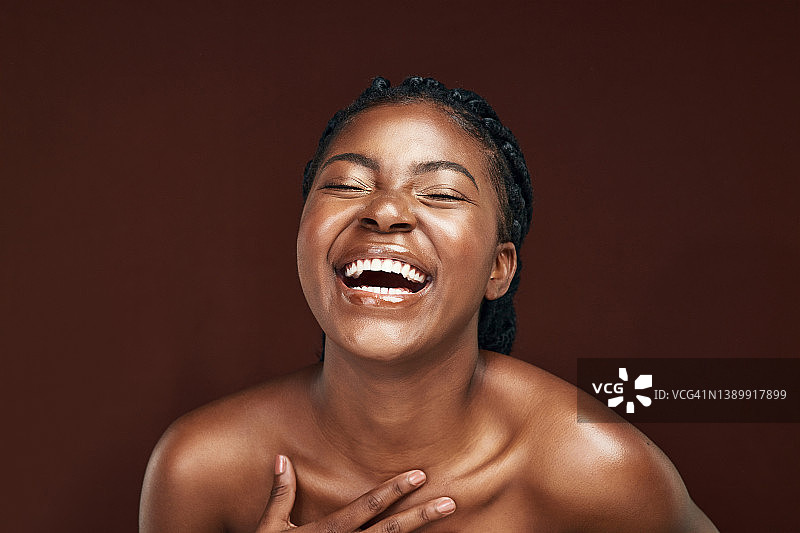 在棕色背景下摆姿势的年轻女子图片素材