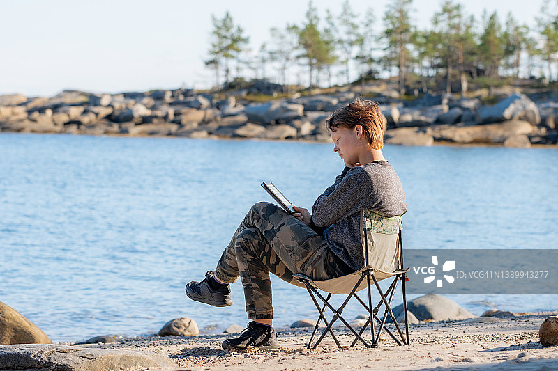 在户外阅读电子书的年轻女人图片素材