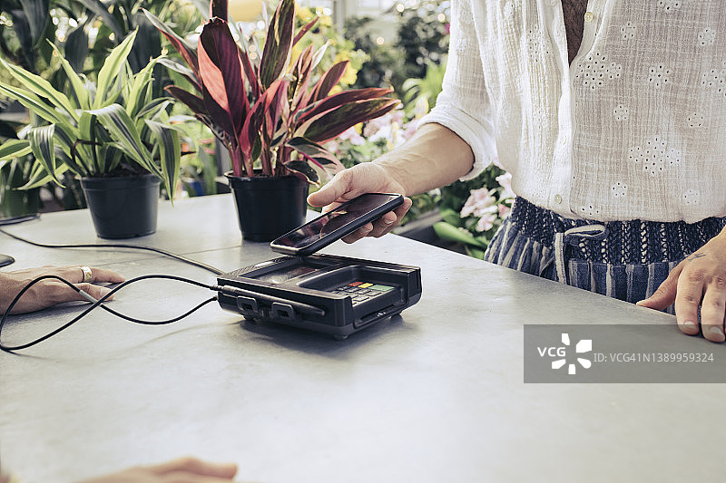 男子用手机进行非接触式支付特写图片素材