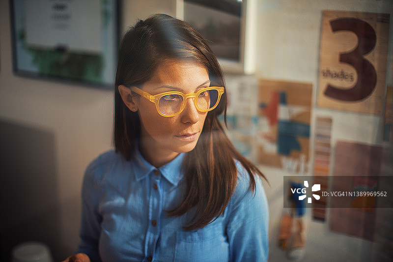 年轻女设计师在家里工作室工作图片素材