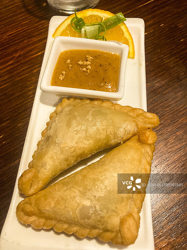 两个马来西亚咖喱角和沙爹蘸酱托盘图片素材