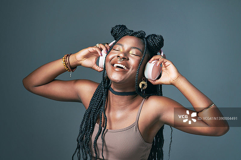 戴着耳机的时尚年轻女性摄影棚照图片素材