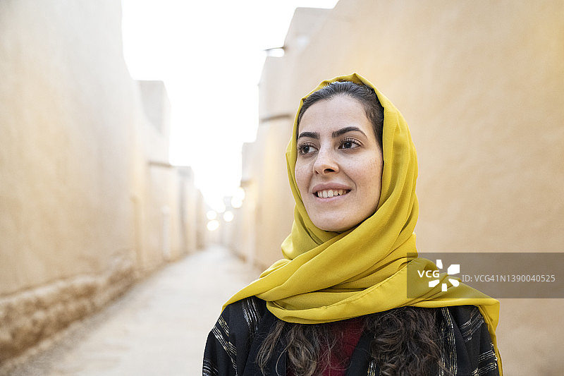 身穿沙特服装的中年微笑女性的抓拍肖像图片素材