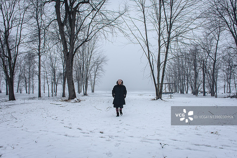 在卡沃瑟湖被雪包围的行走女性正面图图片素材