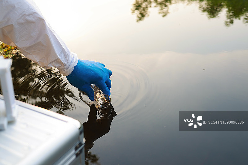环境工程师从工业运河收集废水样本图片素材