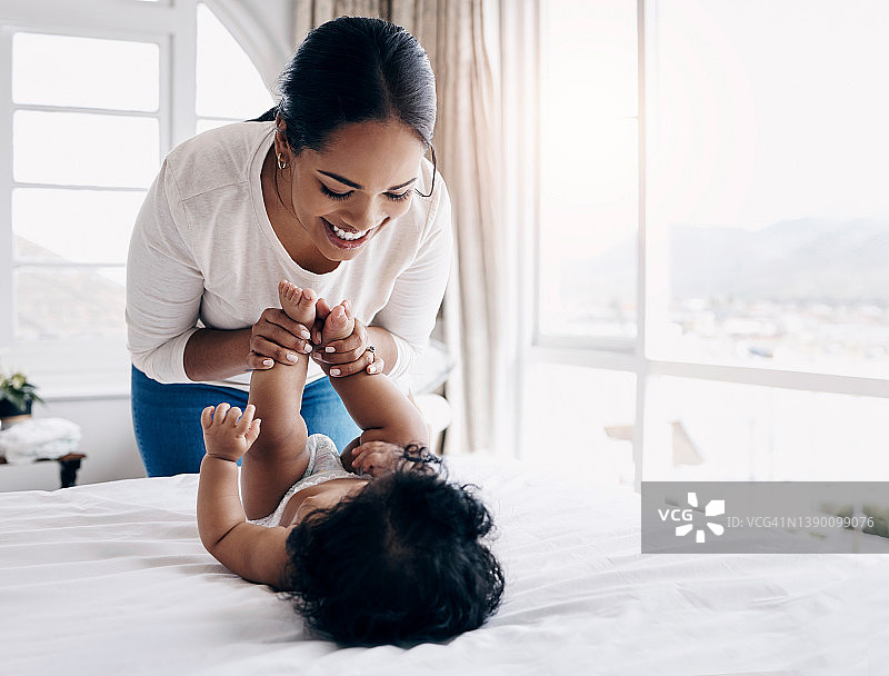 年轻妈妈在家给宝宝换尿布图片素材