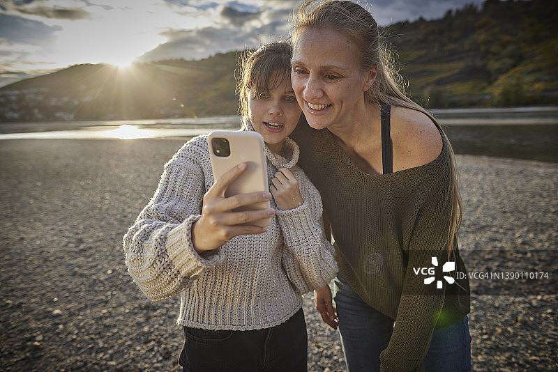 母女在河岸边使用智能手机图片素材