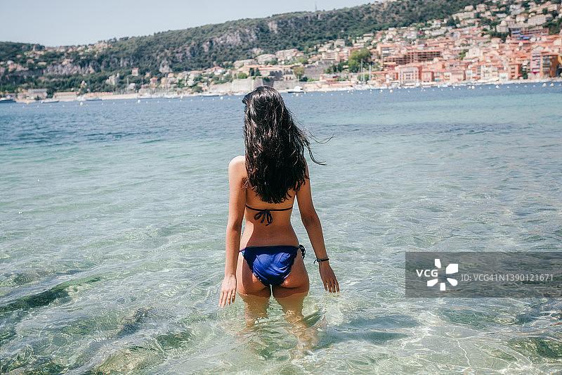 在法国尼斯潜入清澈水中的西班牙裔年轻女子图片素材
