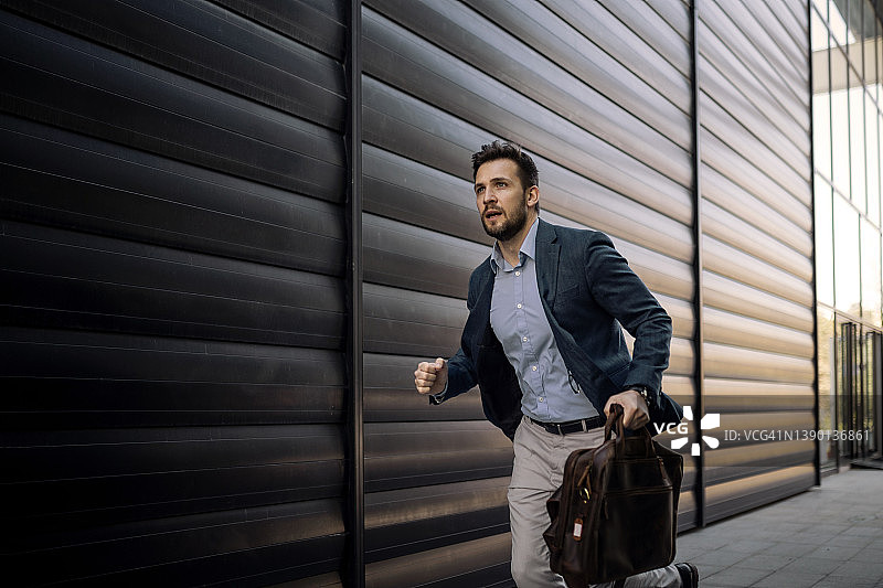年轻商人拿着包迟到了图片素材