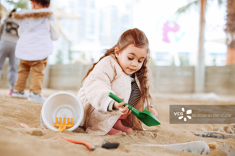 可爱的小女孩在淡季的海滩上玩耍图片素材