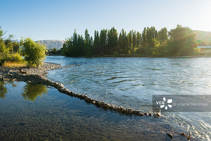 水色和茂盛的树叶与晴朗的天空图片素材
