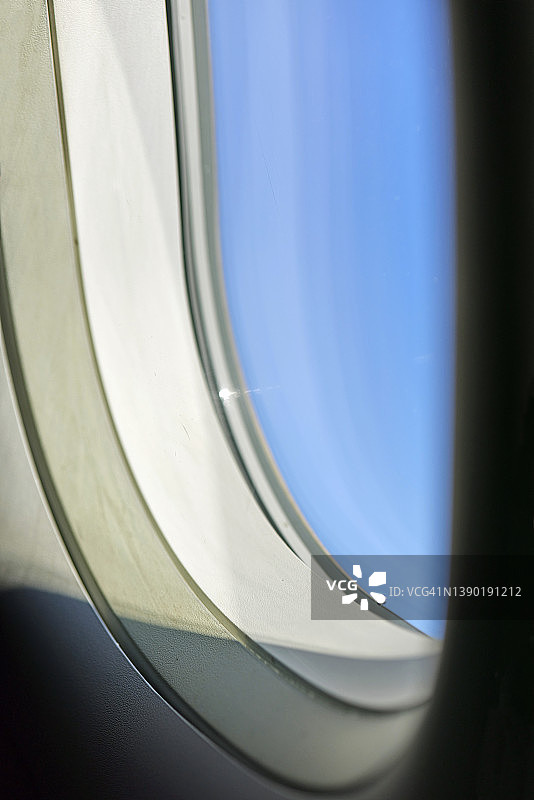飞机机舱窗外的蓝色天空阳光，特写图片素材