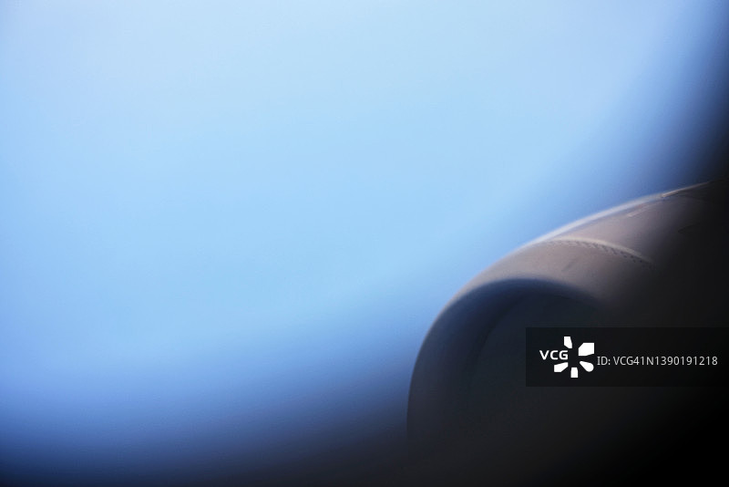 飞机舷窗视角：喷气发动机与蔚蓝天空图片素材