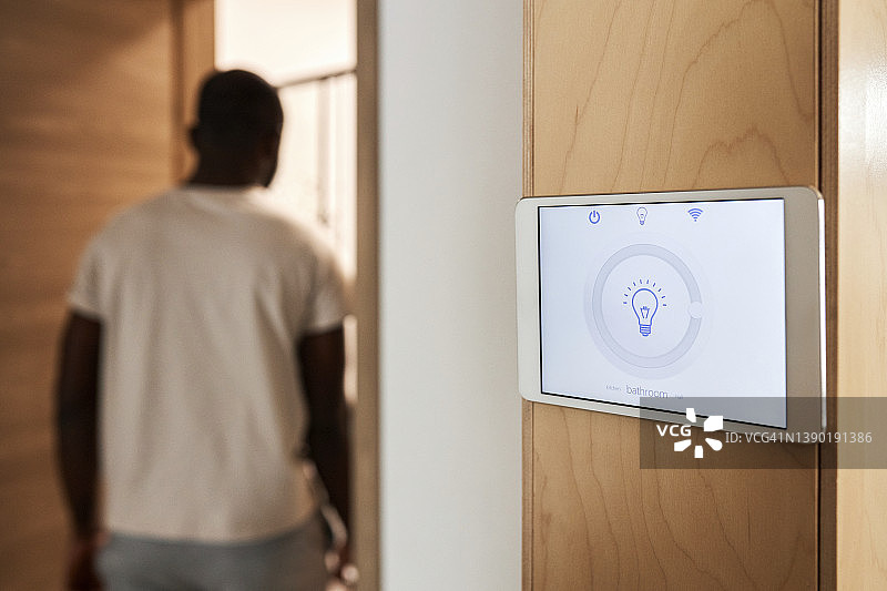 安装在墙上的平板电脑上的智能家居照明系统图片素材