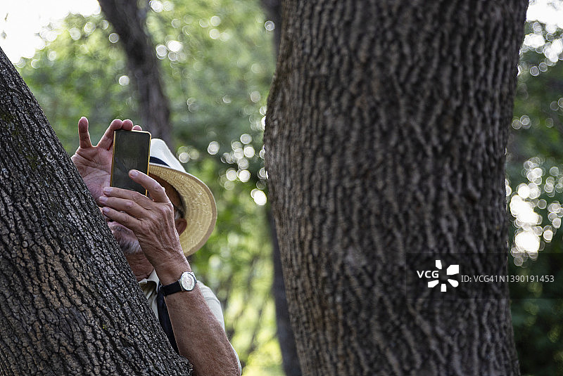 老年男人在克罗地亚希贝尼克-克宁Krka国家公园用智能手机拍照图片素材