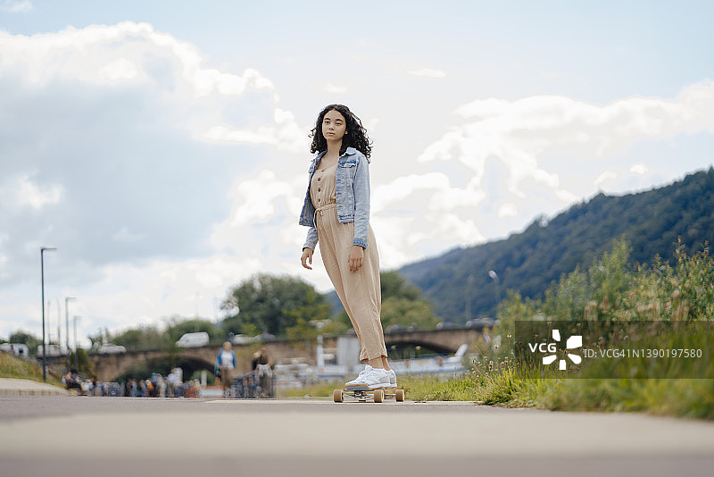 少女在街上玩滑板图片素材