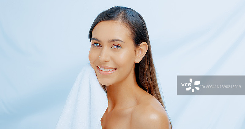 一位用毛巾擦脸的女士的影棚照片图片素材