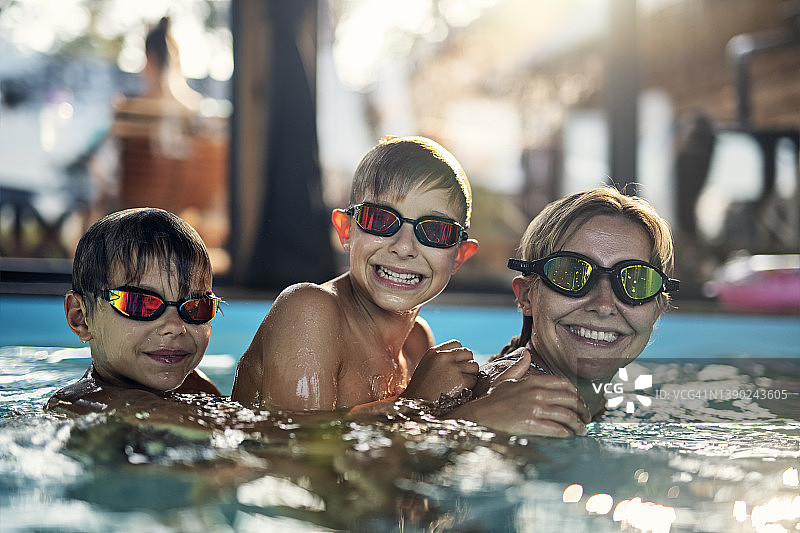 母亲和儿子们在室内游泳池玩耍图片素材