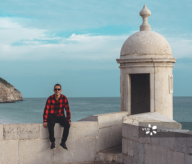 男人坐在圣地亚哥堡垒的墙上图片素材
