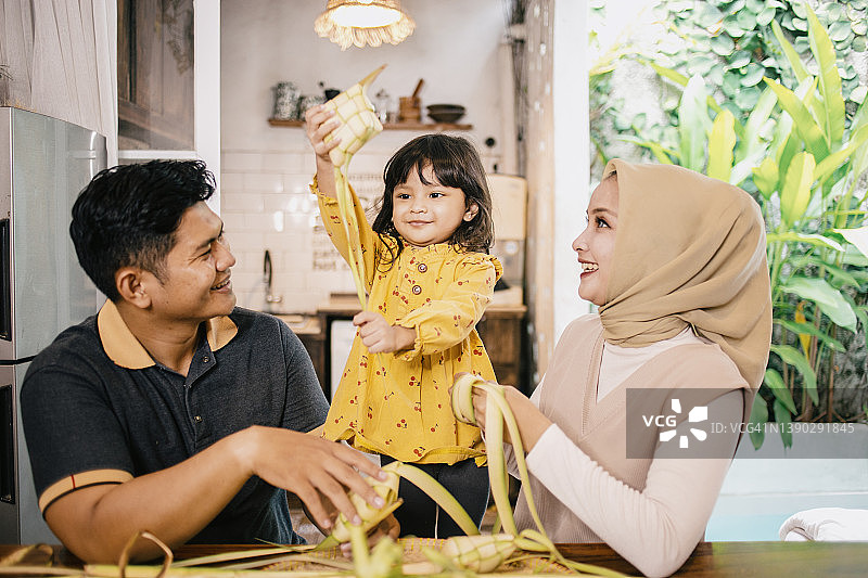年轻的印度尼西亚家庭在家准备马来粽庆祝开斋节图片素材