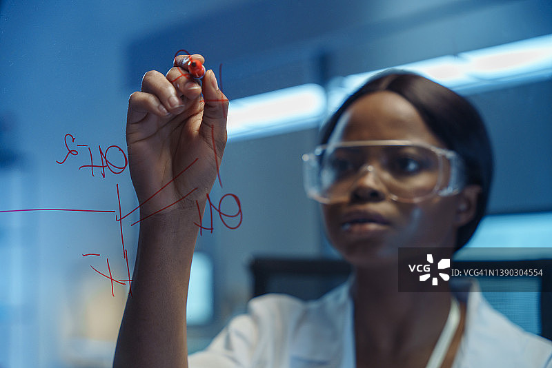 一位年轻的非裔美国科学家在制药领域研究化学公式图片素材