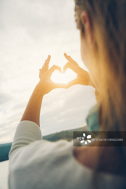 在帆船上用手指比心的女士图片素材