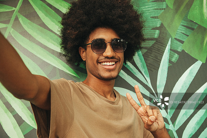 一个发型独特的非洲裔男人在户外使用手机图片素材