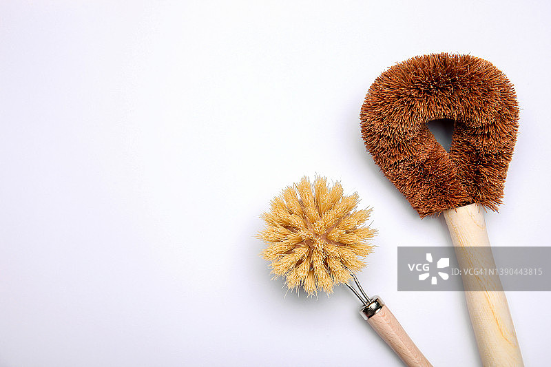 浅色背景上的天然椰棕纤维多用途洗涤刷。白色背景厨房天然刷子的顶视图，带有文本空间图片素材