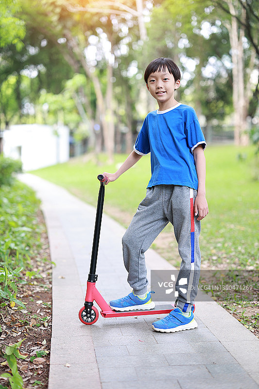 骑滑板车的亚洲男孩图片素材