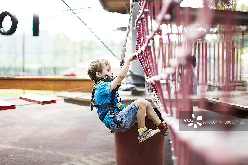 在滑索公园玩耍的小男孩图片素材