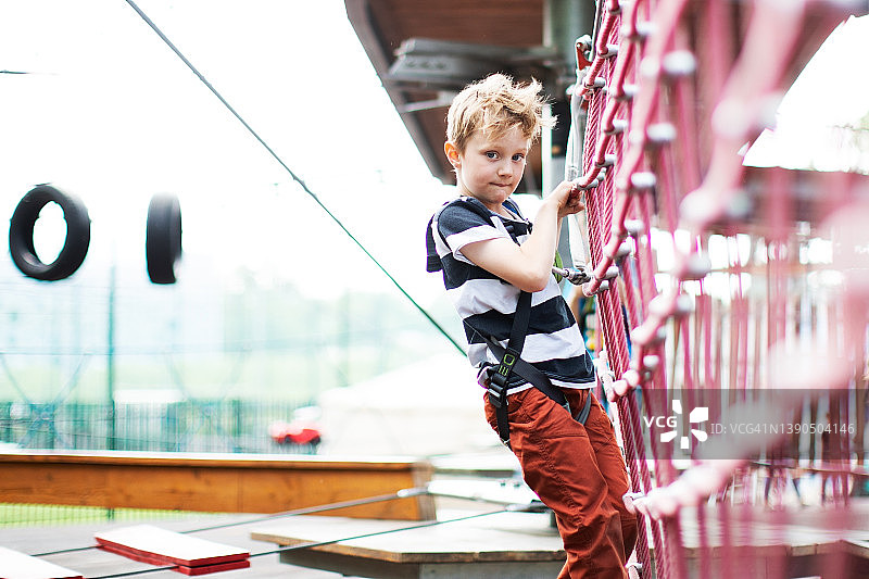 在滑索公园玩耍的小男孩图片素材