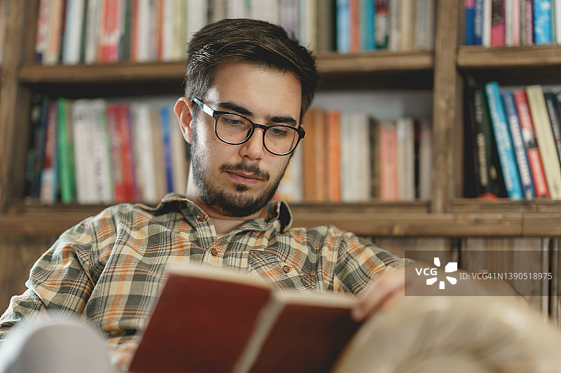 年轻男人在图书馆阅读书籍图片素材