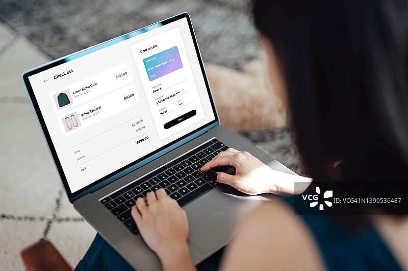 女人在笔记本电脑上在线购买服装，并使用信用卡付款图片素材
