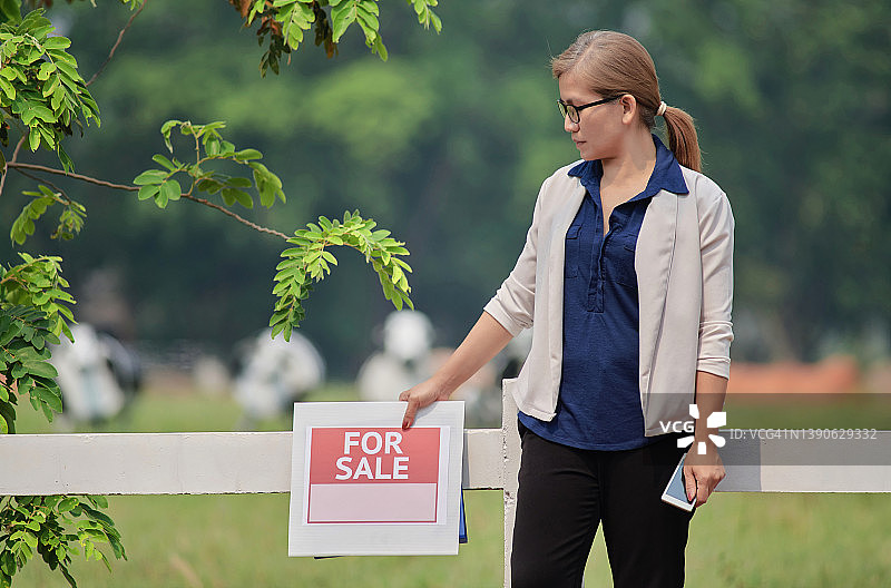 手持销售标志的房地产经纪人肖像图片素材
