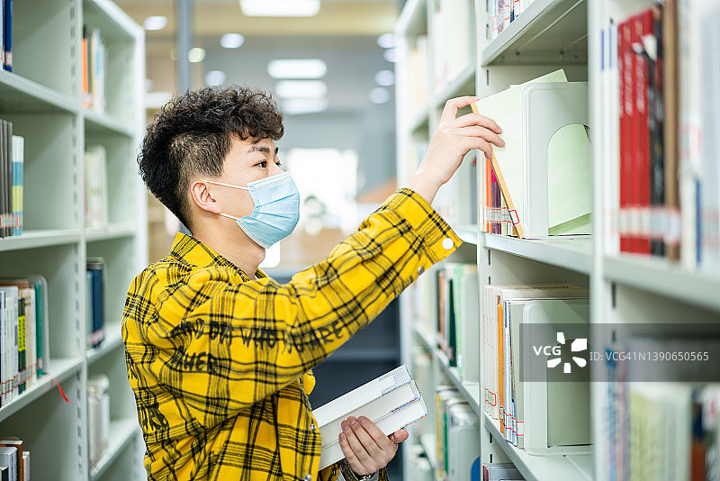 亚洲成年学生在图书馆借书图片素材