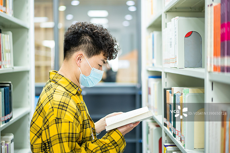 亚洲成年学生在图书馆借书图片素材