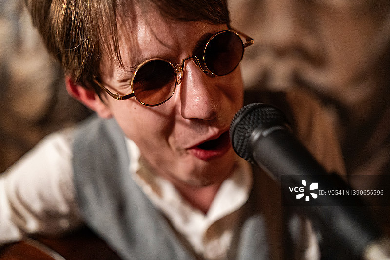 年轻男子在麦克风前唱歌图片素材