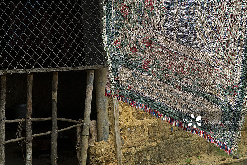 在西非利比里亚偏远村庄的线上挂着一条写着“当上帝关上一扇门，他会打开一扇窗”的毯子图片素材