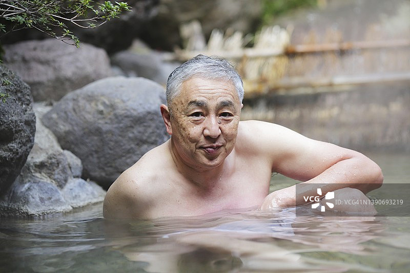 老年男泡在户外的日本温泉图片素材