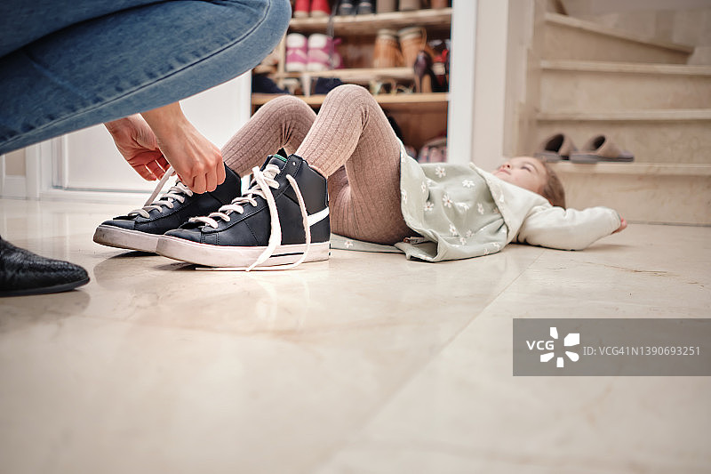 母亲给小女儿穿拖鞋图片素材