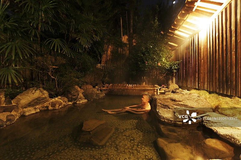 男性在户外日式温泉中浸泡图片素材