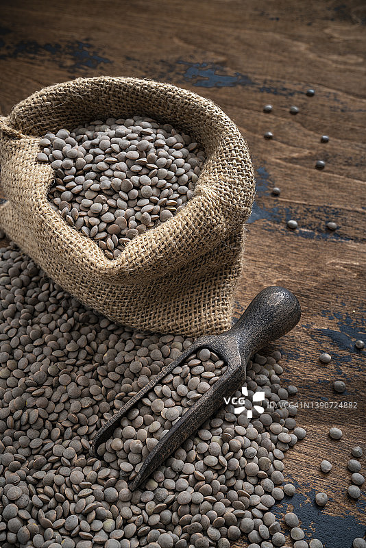 粗麻布袋中的帕尔迪纳棕色小扁豆和木制勺子图片素材
