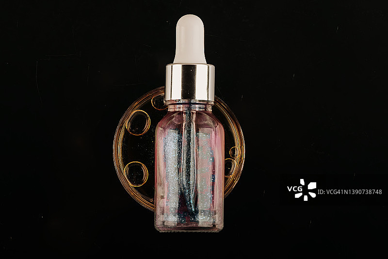 黑色背景上油性滴剂的化妆品滴管特写图片素材
