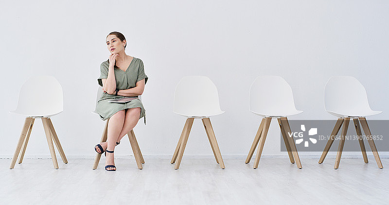 有魅力的年轻女商人独自坐在办公室里，等待面试图片素材