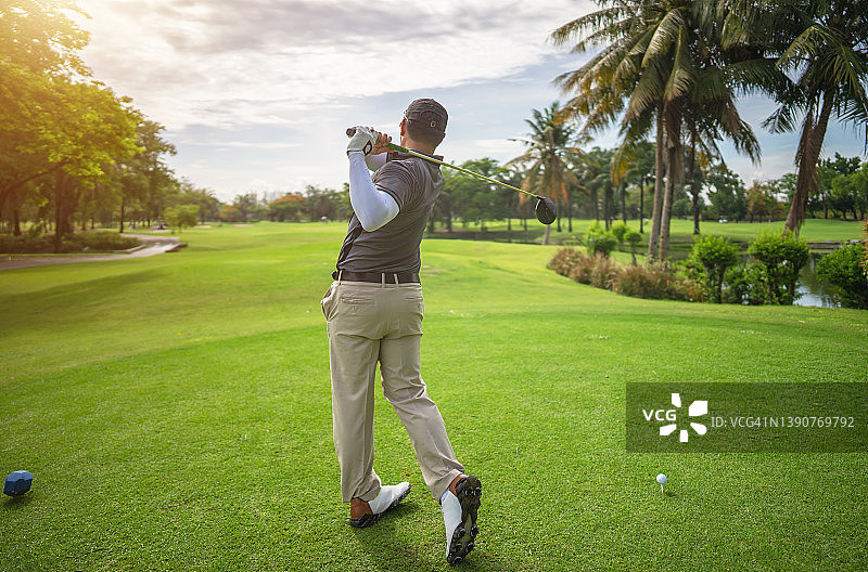 高尔夫球手在夏季度假时用球杆在球场上击球图片素材