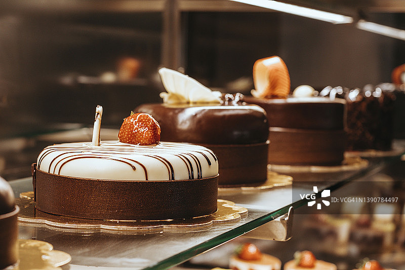 糕点店玻璃橱窗中展示的各类蛋糕图片素材